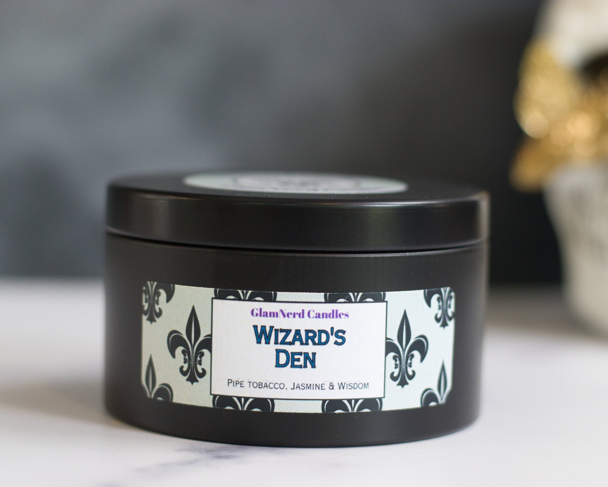 picture of Wizard's Den candle in a black tin sitting on a white marble surface